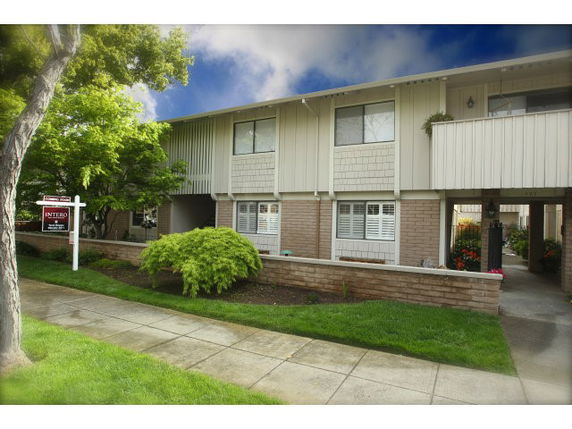 Front view of a two-story townhouse with a small front yard.