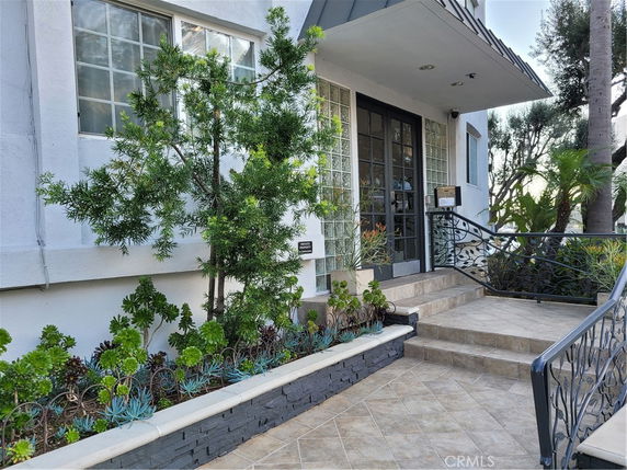 Entrance view of a building with glass block windows and a tiled staircase.