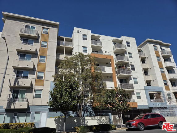 Front view of a multi-story apartment building with balconies.