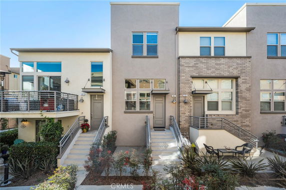 Front view of a row of modern townhouses with stairs leading to each entrance.