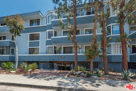 Front view of a multi-story building with balconies and blue exterior siding.