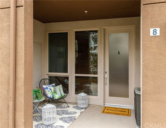 Front view of a house entrance with a glass door and windows.