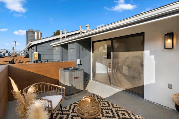 Rooftop area with seating and air conditioning unit.