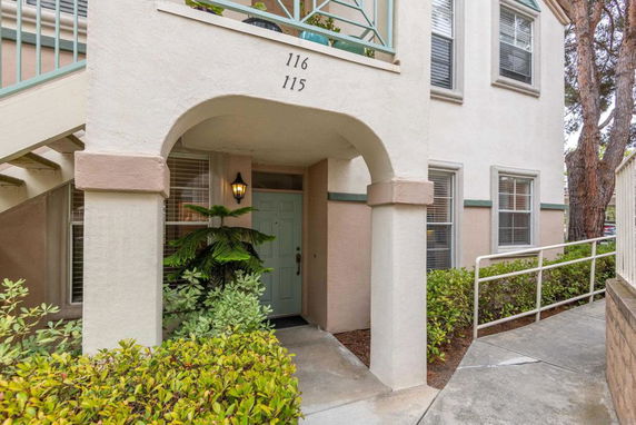 Front view of a multi-story residential building entrance with an archway.