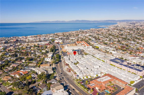 Aerial view of a cityscape with a coastal shoreline and numerous buildings and houses.