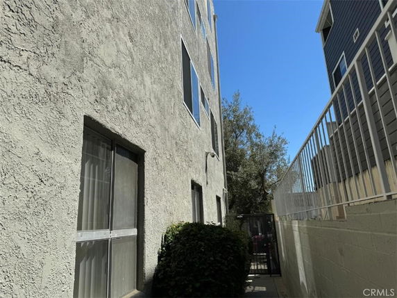 Side view of a multi-story building with textured facade and windows.