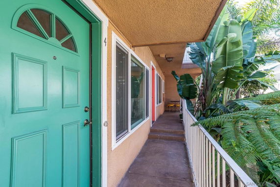 Front view of a building entrance with a green door and a walkway.