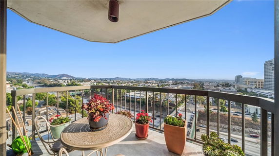 Balcony view overlooking a cityscape with mountains in the distance.
