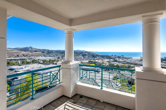 Panoramic view from a balcony overlooking the ocean and surrounding landscape.