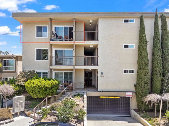 Front view of a multi-story apartment building with balconies.