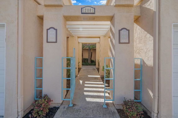 Front view of a building entryway with marked unit numbers and decorative blue metal designs.