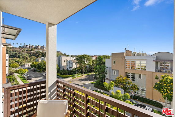 View from a balcony overlooking residential buildings and trees.