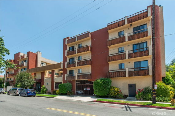 Front view of a multi-story apartment building with balconies.