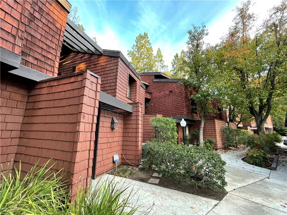 Front view of a multi-story house with wood siding and contemporary architectural design.