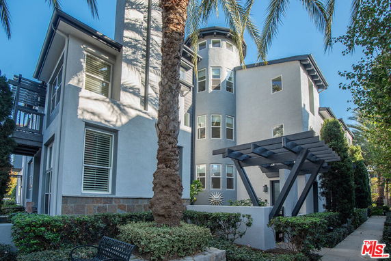 Front view of a multi-story building with large windows and a small veranda.