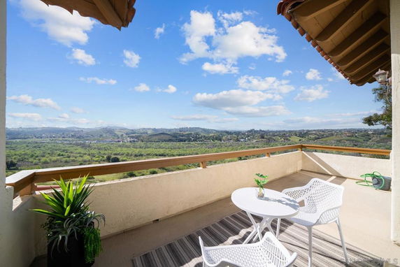 Wide angle view from a balcony overlooking a landscape with hills and clear sky.
