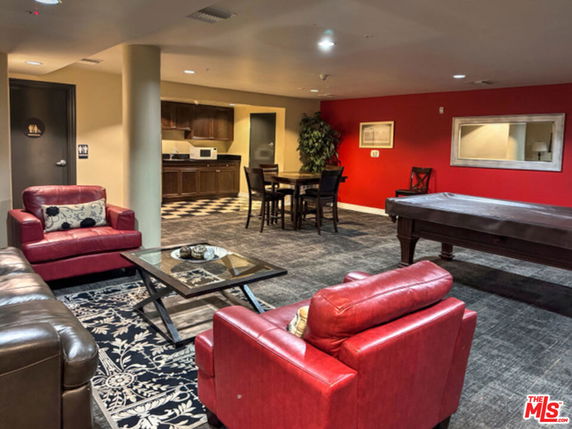 Interior view of a recreational area with seating and a pool table.