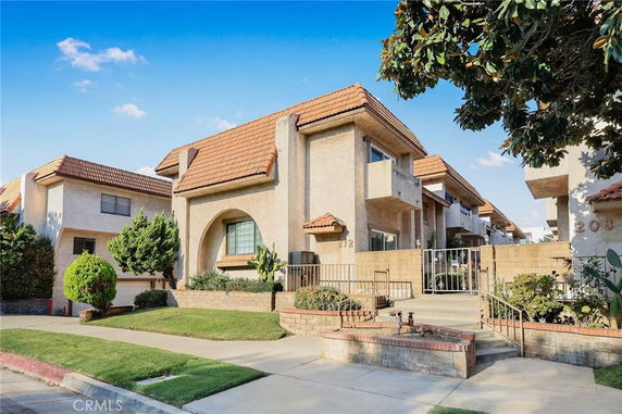 Front view of a two-story house with a gated entrance and tiled roof.