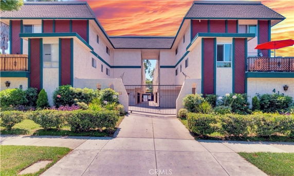 Front view of a multi-story residential building with a gated entrance.