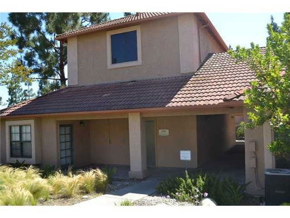 Front view of a two-story house with a sloped roof and covered entrance.