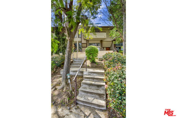 Front view of a house with stairs leading to the entrance.
