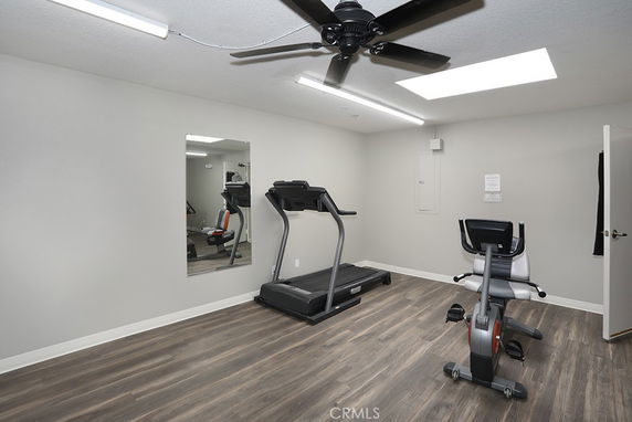 Indoor room with exercise equipment including a treadmill and stationary bike.