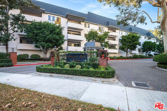 Front view of a multi-story building with a landscaped entrance.