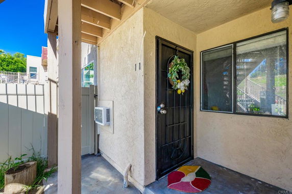 Front view of a residential entrance with a decorated door and small window.