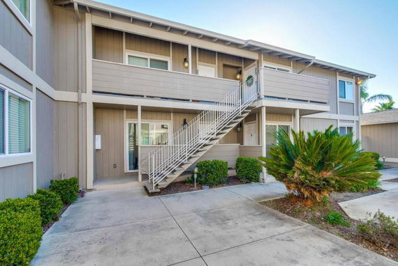 Front view of a two-story residential building with an exterior staircase.