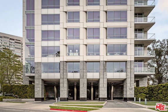 Front view of a multi-story building with large windows and balconies.