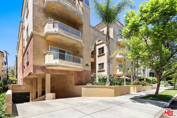 Front view of a multi-story apartment building with balconies.