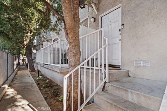 Front view of a house with a concrete entrance and a railing along the steps.