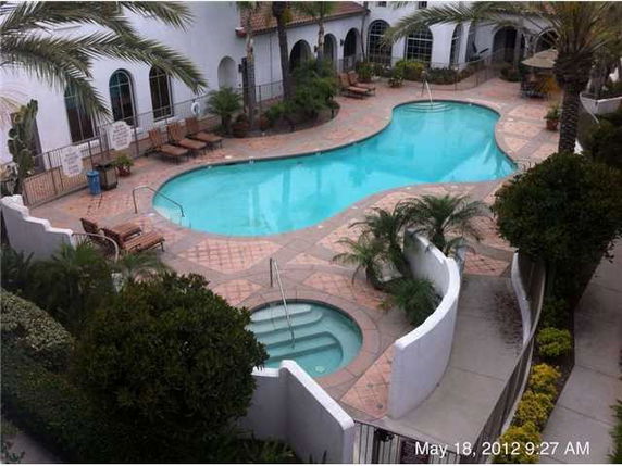 Outdoor swimming pool area with surrounding lounge chairs and landscaping.