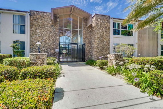 Front view of a building with a stone facade and glass entryway.