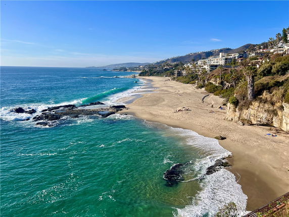 Panoramic view of a coastline with sandy beach and rocky shoreline.