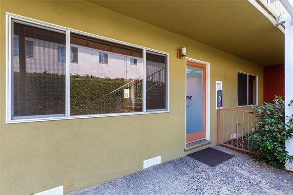 Front view of a building entrance with large windows and a door marked 'FIVE'.