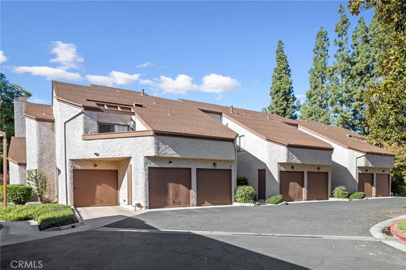 Front view of townhouses with sloped roofs and attached garages.