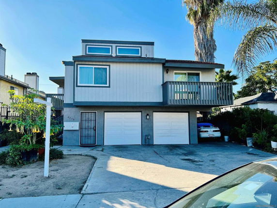 Front view of a two-story house with a balcony and double garage.
