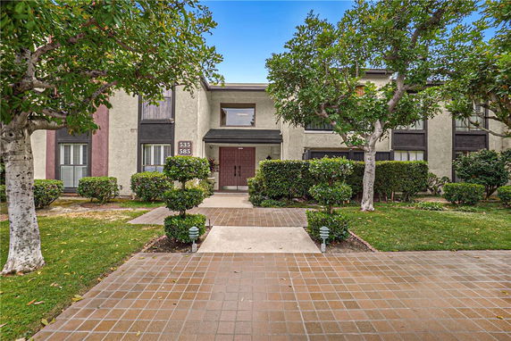 Front view of a two-story residential building with a pathway leading to the entrance.