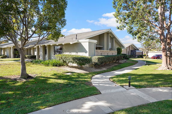 Front view of a single-story house with a sloped roof and landscaped garden.