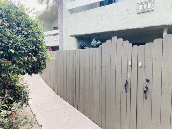 Front view of a building with a wooden fence and pathway.