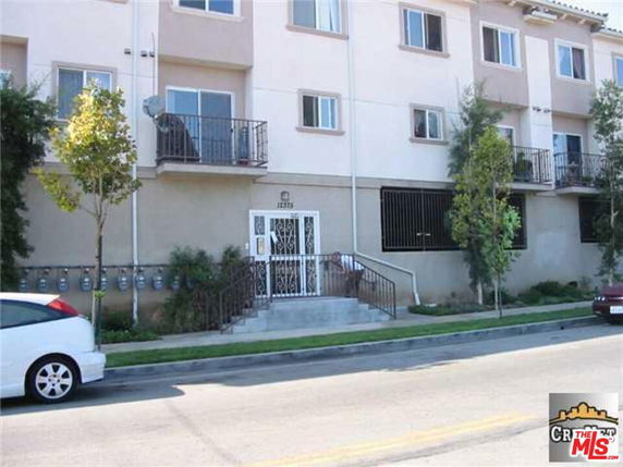Front view of a multi-story residential building with balconies.
