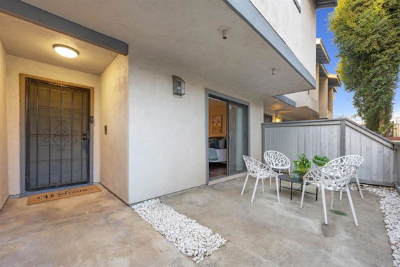 Front view of a building entrance with a patio area and metal gate.