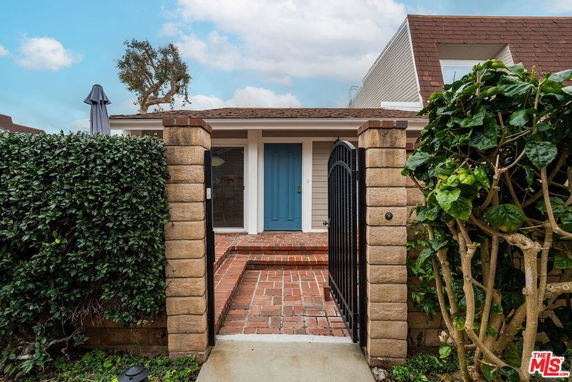 Front view of a house with brick pathway leading to a blue door.
