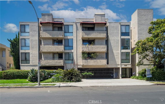 Front view of a multi-story apartment building with balconies.