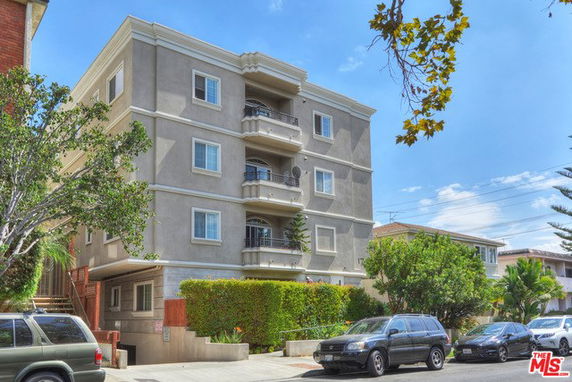 Front view of a four-story apartment building with balconies.