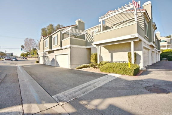 Front view of a multi-story building with garages on the ground level.