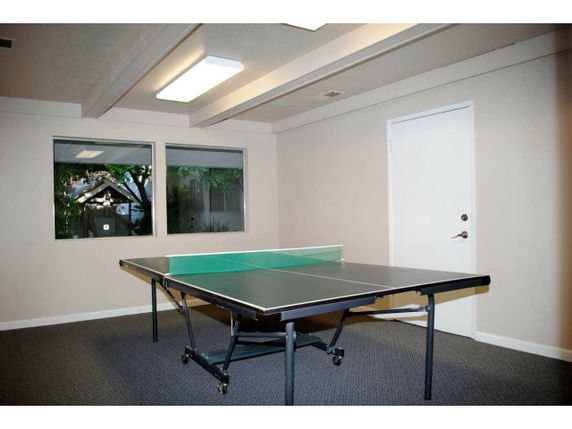 Room with a ping pong table and a door leading outside.