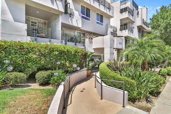 Front view of a modern multi-story condominium building with balconies.