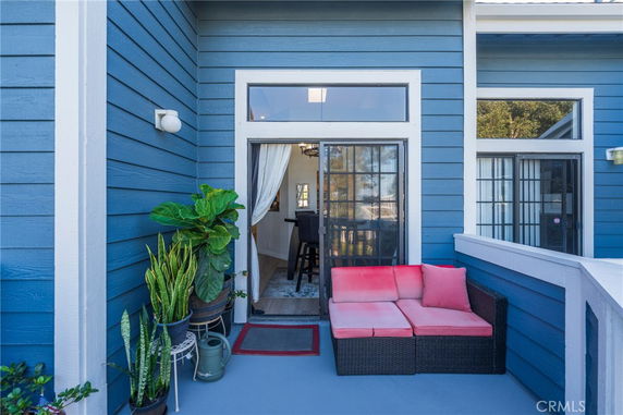 Front view of a building's blue exterior with a patio area and sliding glass doors.